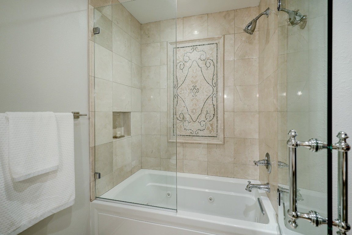 6599 Bayou Glen Road Houston, TX 77057 - Photo 35 of 41 Opposite the vanity is a jetted tub with shower combination, stunning marble tile inlay and seamless shower door.
