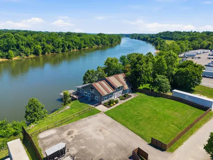 an aerial view of a house with a garden and lake view