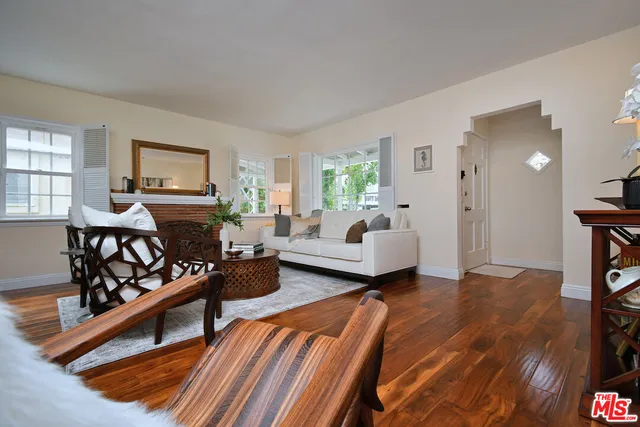 a living room with furniture and a potted plant on a dresser