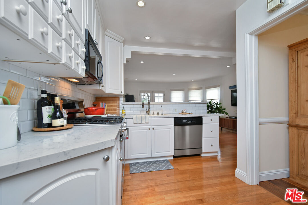 4226 Greenbush Avenue Sherman Oaks, CA 91423 - Photo 31 of 69 a kitchen with stainless steel appliances kitchen island granite countertop a refrigerator and stove