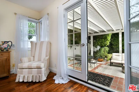 a view of a patio with table and chairs with wooden floor and fence