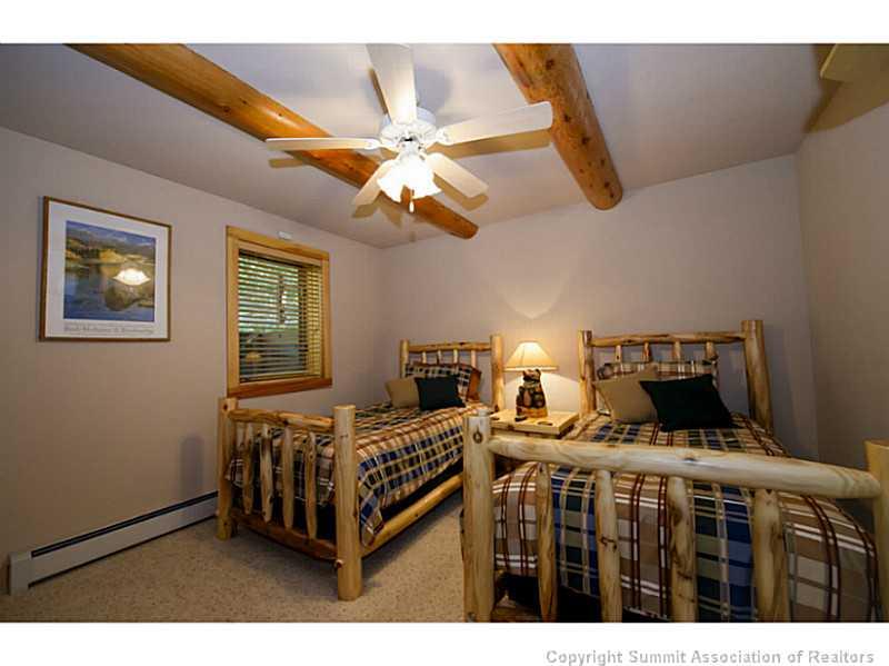 311 Red Hawk Circle Silverthorne, CO 80498 - Photo 15 of 25 a bedroom with a bed a window and a chandelier