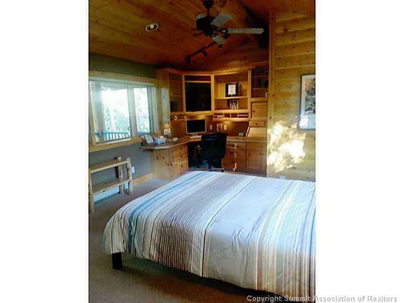 311 Red Hawk Circle Silverthorne, CO 80498 - Photo 19 of 25 a bedroom with a bed and a chandelier