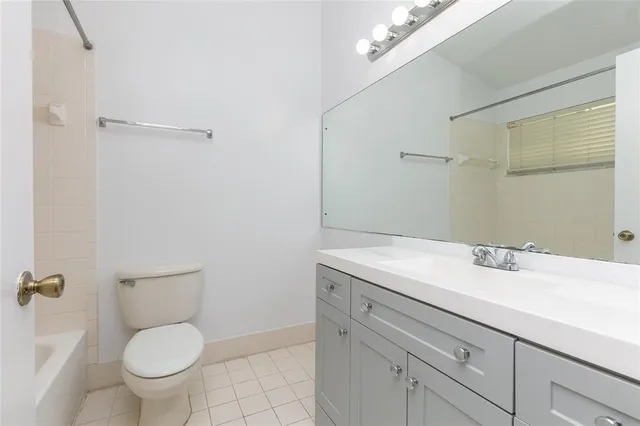 a bathroom with a granite countertop toilet sink and mirror