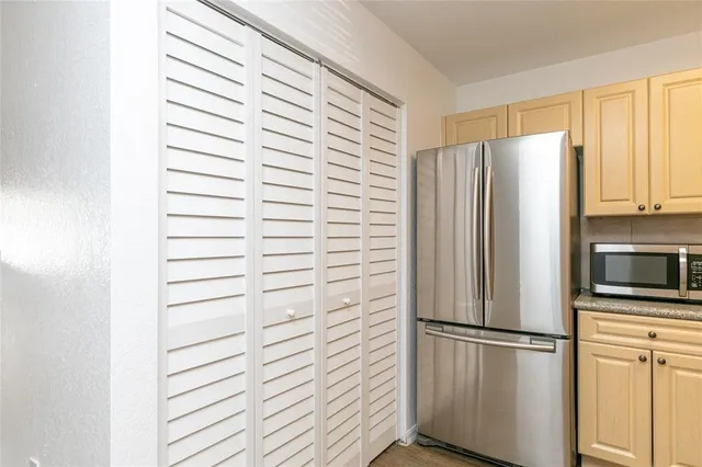 a white refrigerator freezer and a wooden floor
