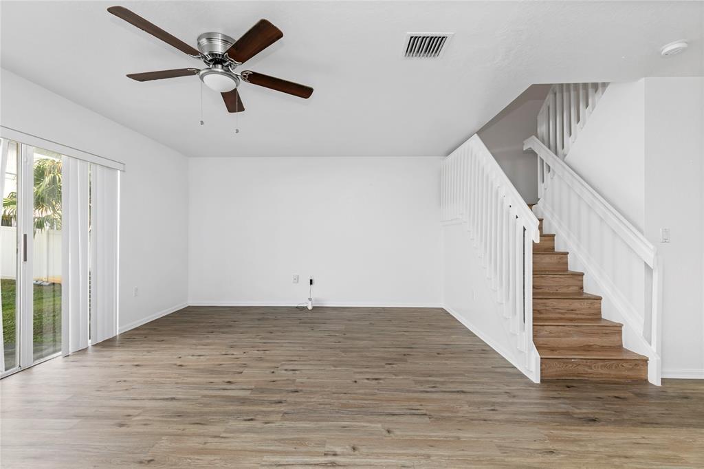 159 Hidden Ct Road, Unit I49 Hollywood, FL 33023 - Photo 9 of 21 a view of an empty room with wooden floor and a ceiling fan