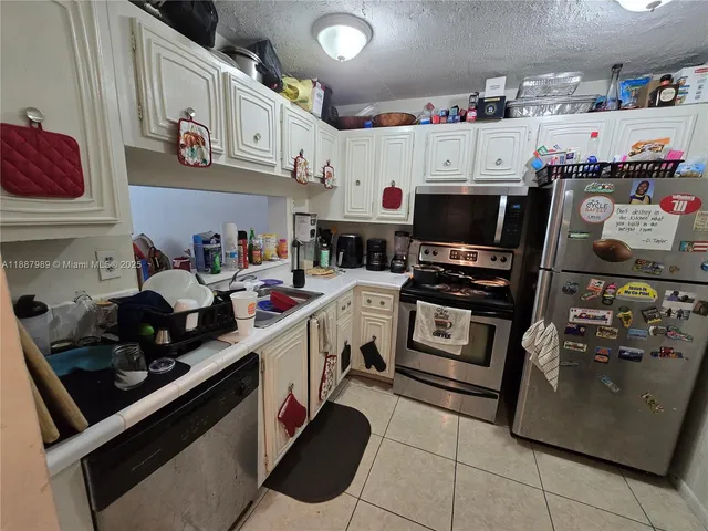 a kitchen with a white stove top oven and cabinets