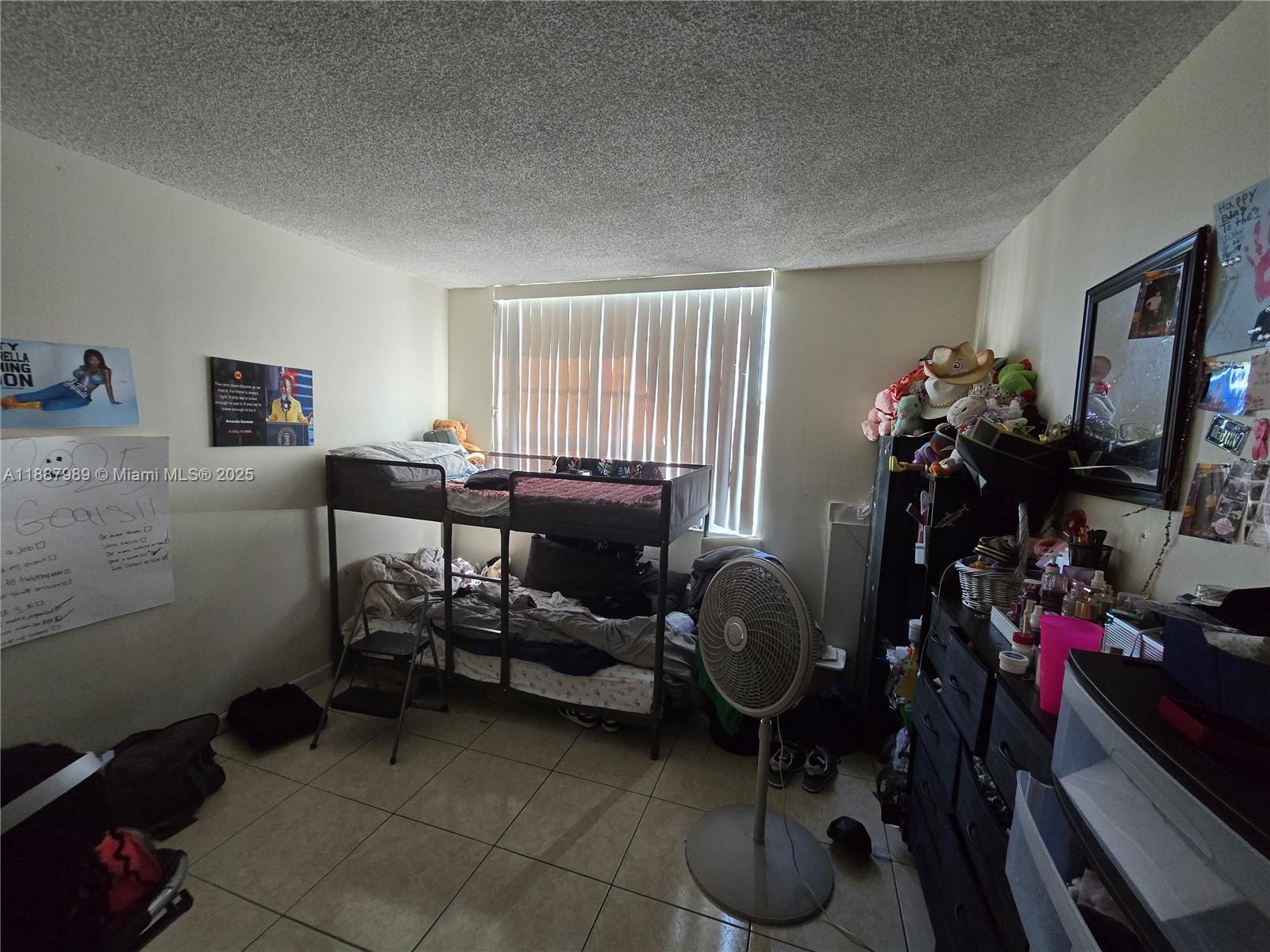 498 Northwest 165th Street, Unit D405 Miami, FL 33169 - Photo 5 of 12 a room with furniture and a flat screen tv