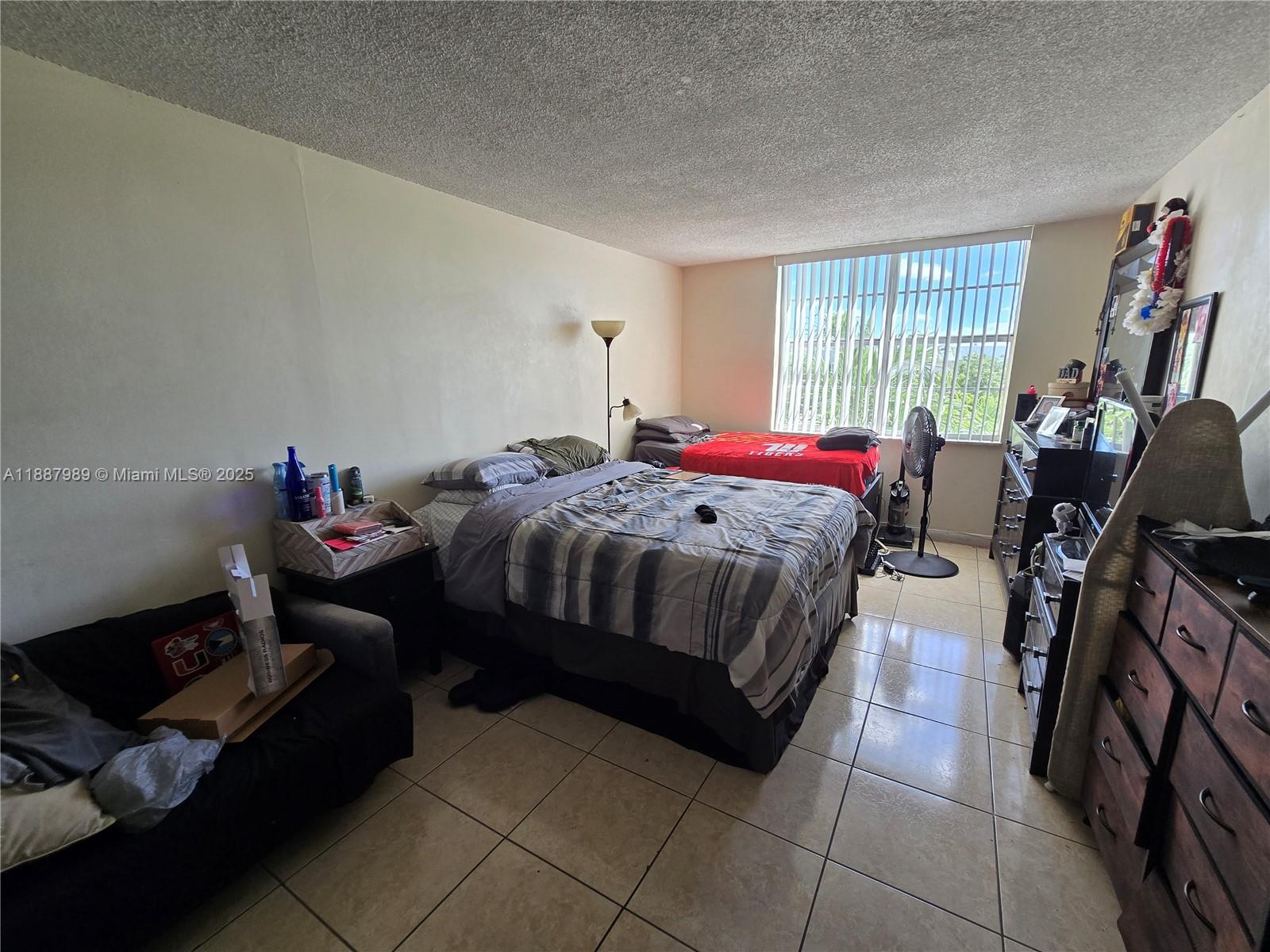 498 Northwest 165th Street, Unit D405 Miami, FL 33169 - Photo 7 of 12 a bedroom with a bed and a window