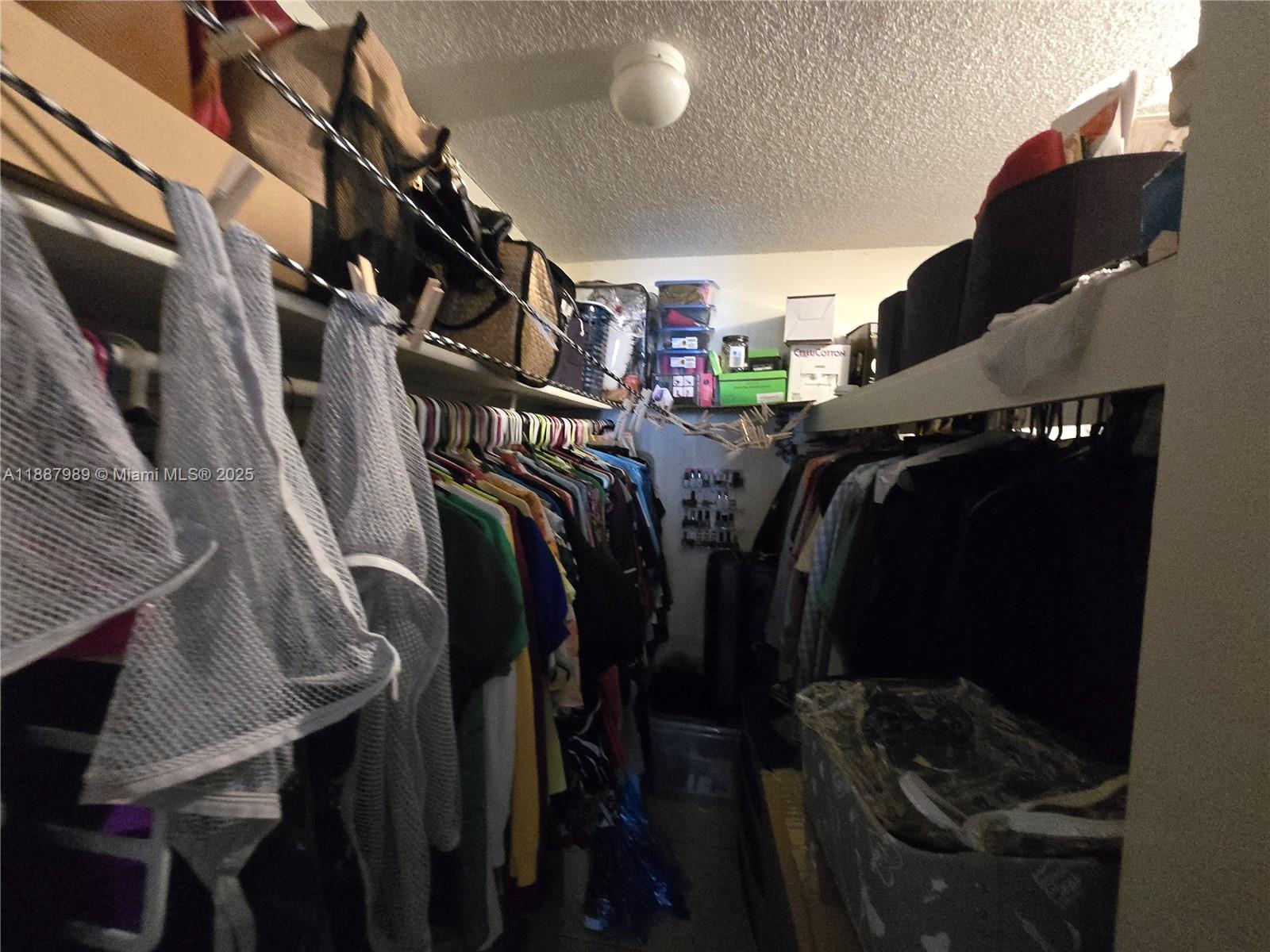 498 Northwest 165th Street, Unit D405 Miami, FL 33169 - Photo 9 of 12 a view of walk in closet with clothes and shoes