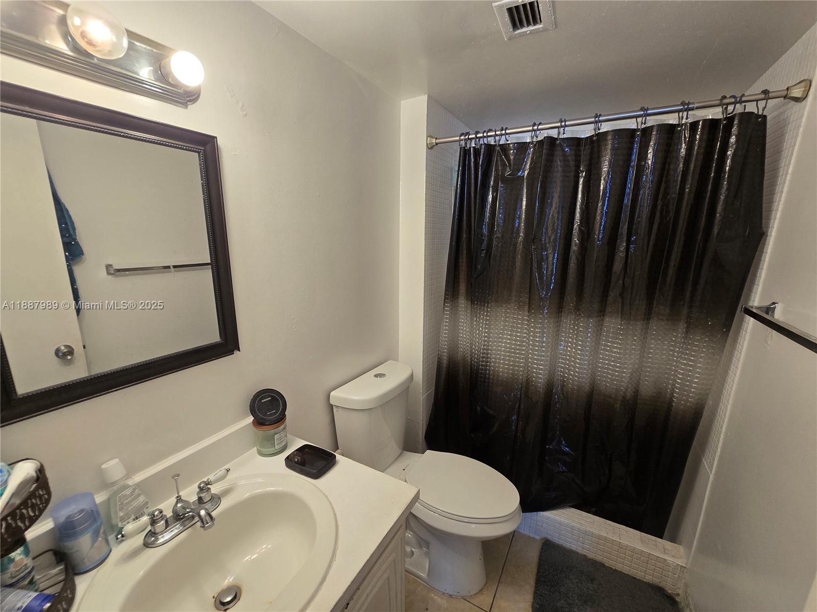 498 Northwest 165th Street, Unit D405 Miami, FL 33169 - Photo 10 of 12 a bathroom with a sink a toilet and mirror