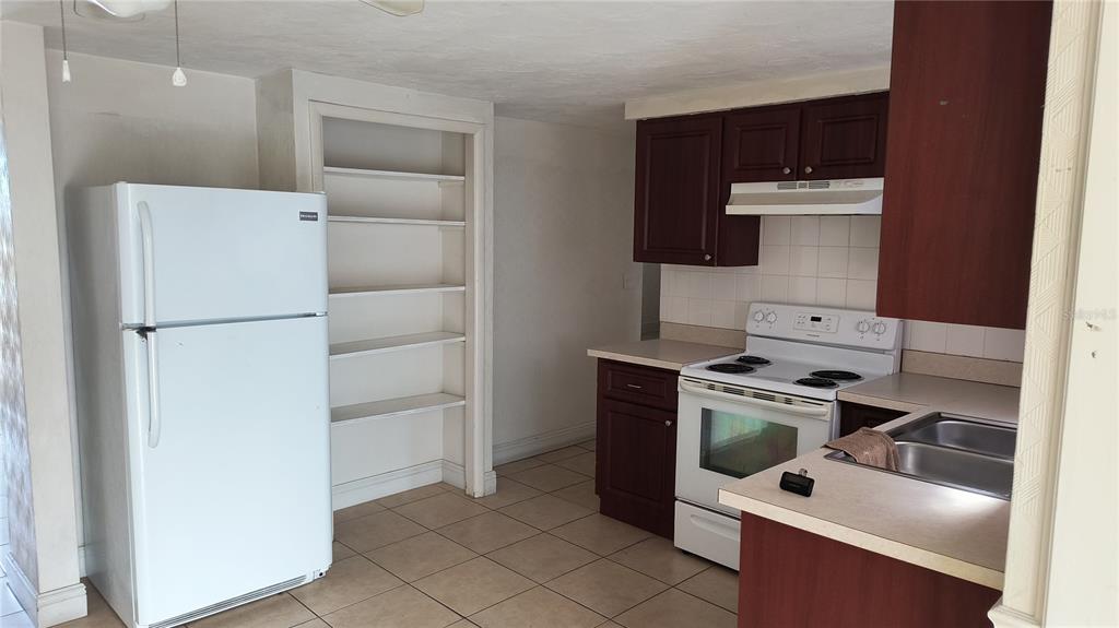 3910 Darlington Road Holiday, FL 34691 - Photo 5 of 11 a kitchen with a refrigerator sink and cabinets