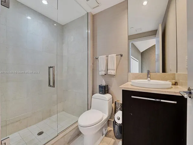 a bathroom with a double vanity sink a toilet and a tub