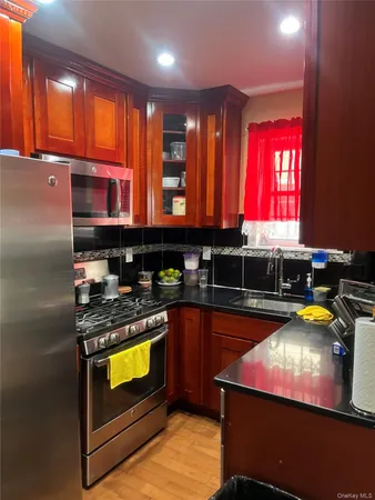 a kitchen with stainless steel appliances granite countertop a stove a sink and a microwave