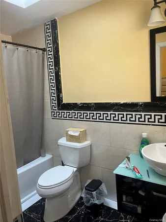 a bathroom with a toilet sink and mirror