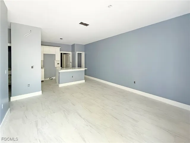 an empty room with kitchen and window