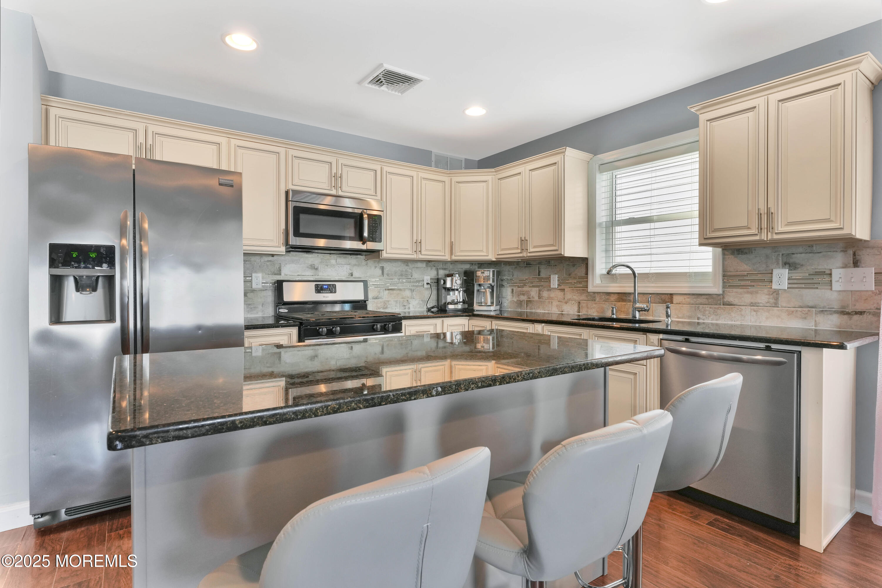 115 Harding Avenue, Unit B Seaside Heights, NJ 08751 - Photo 7 of 16 a kitchen with stainless steel appliances granite countertop a refrigerator a stove a sink a dining table and chairs