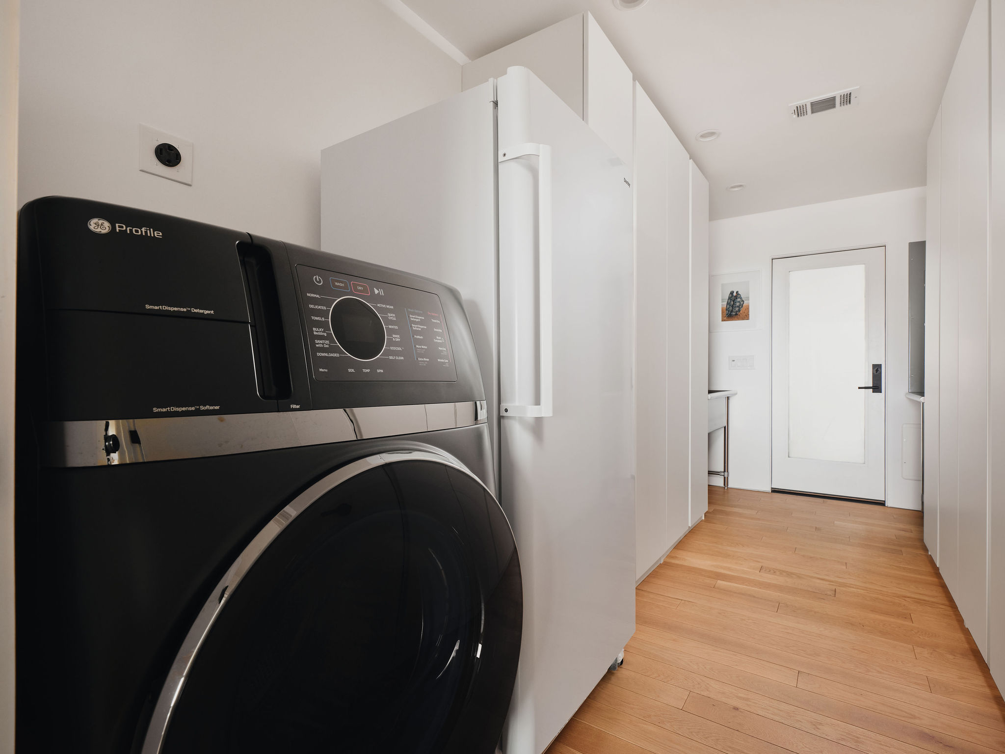 Undisclosed Address Austin, TX 78731 - Photo 24 of 26 Streamlined appliances complement the rich hardwood flooring in this practical laundry and mudroom area.