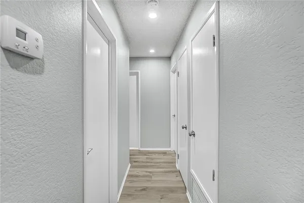 a view of a hallway with wooden floor
