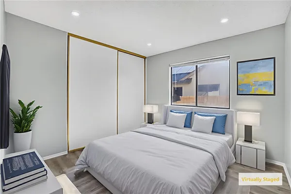 a bedroom with a large bed and a potted plant