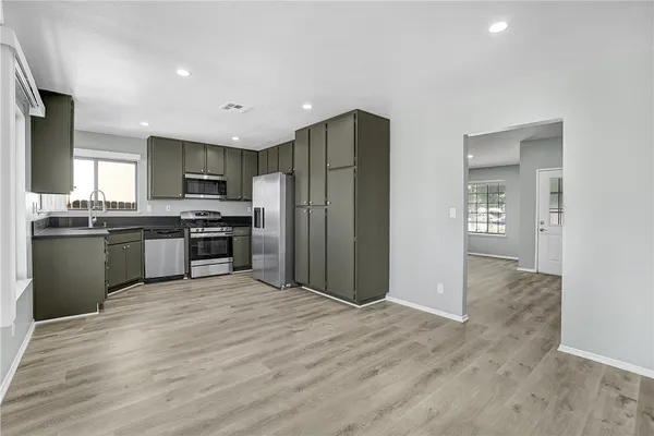 a kitchen with stainless steel appliances granite countertop a refrigerator and a stove top oven