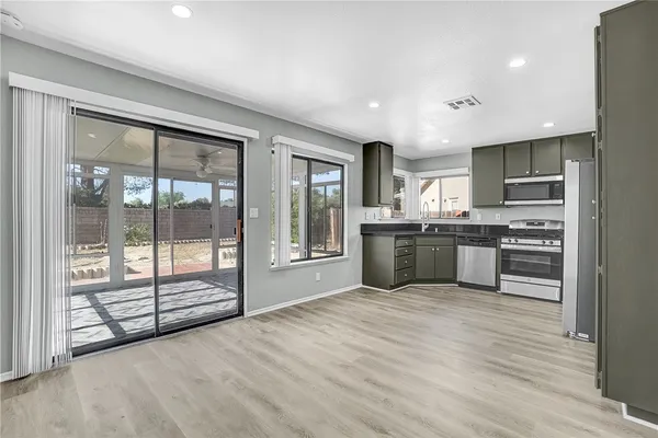 a large kitchen with stainless steel appliances granite countertop a large counter top a stove and a refrigerator