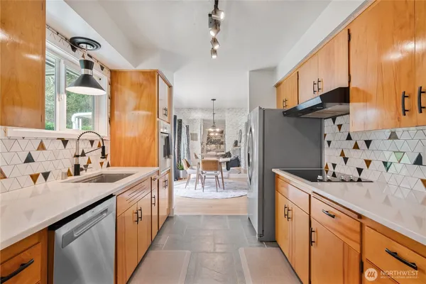 a kitchen with stainless steel appliances kitchen island granite countertop a sink stove and cabinets