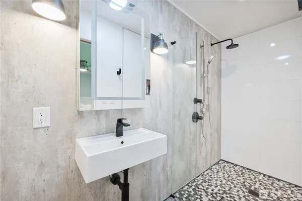a bathroom with a sink a shower and a mirror