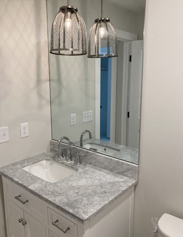 21 Paddock Road Rutland, MA 01543 - Photo 15 of 18 a bathroom with a granite countertop sink a mirror and a toilet