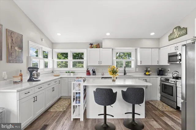 a kitchen with cabinets appliances and a dining table