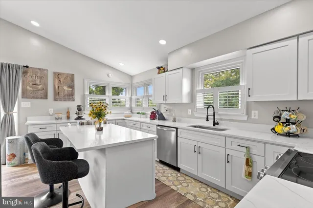 a kitchen with a sink a window and chairs