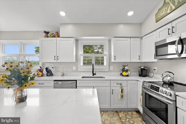 a kitchen with stainless steel appliances granite countertop a sink stove and cabinets
