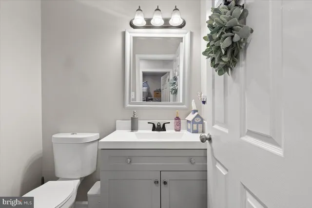 a bathroom with a toilet a sink and mirror
