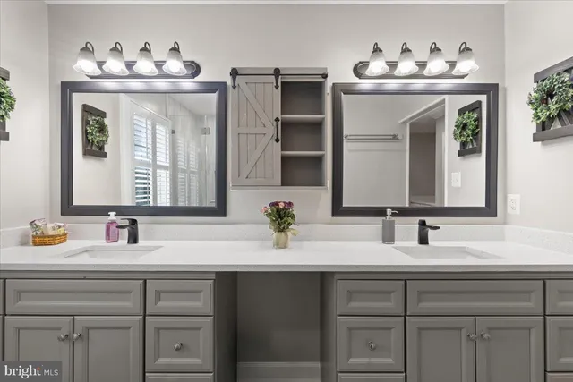 a bathroom with double vanity sinks and a mirror
