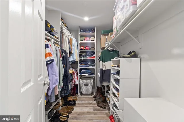 a view of walk in closet with clothes and shoes