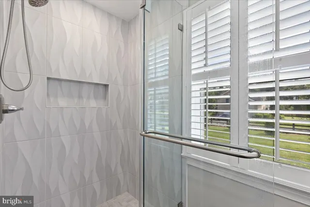 a bathroom with a window and a shower