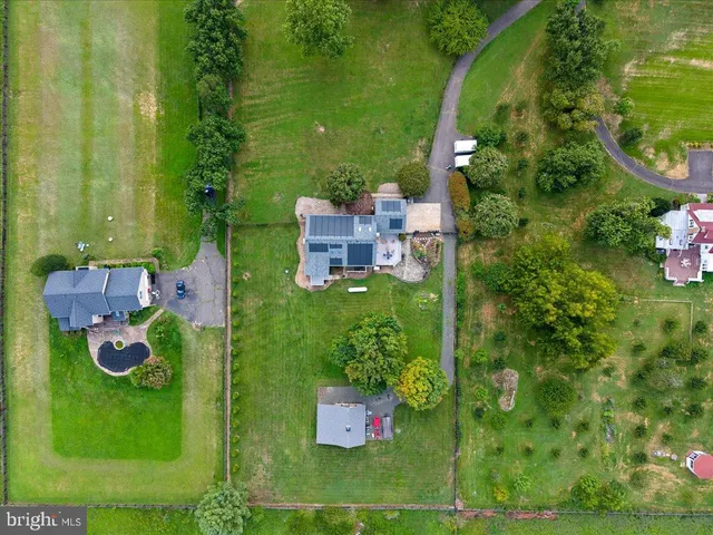 an aerial view of a house with garden space and street view