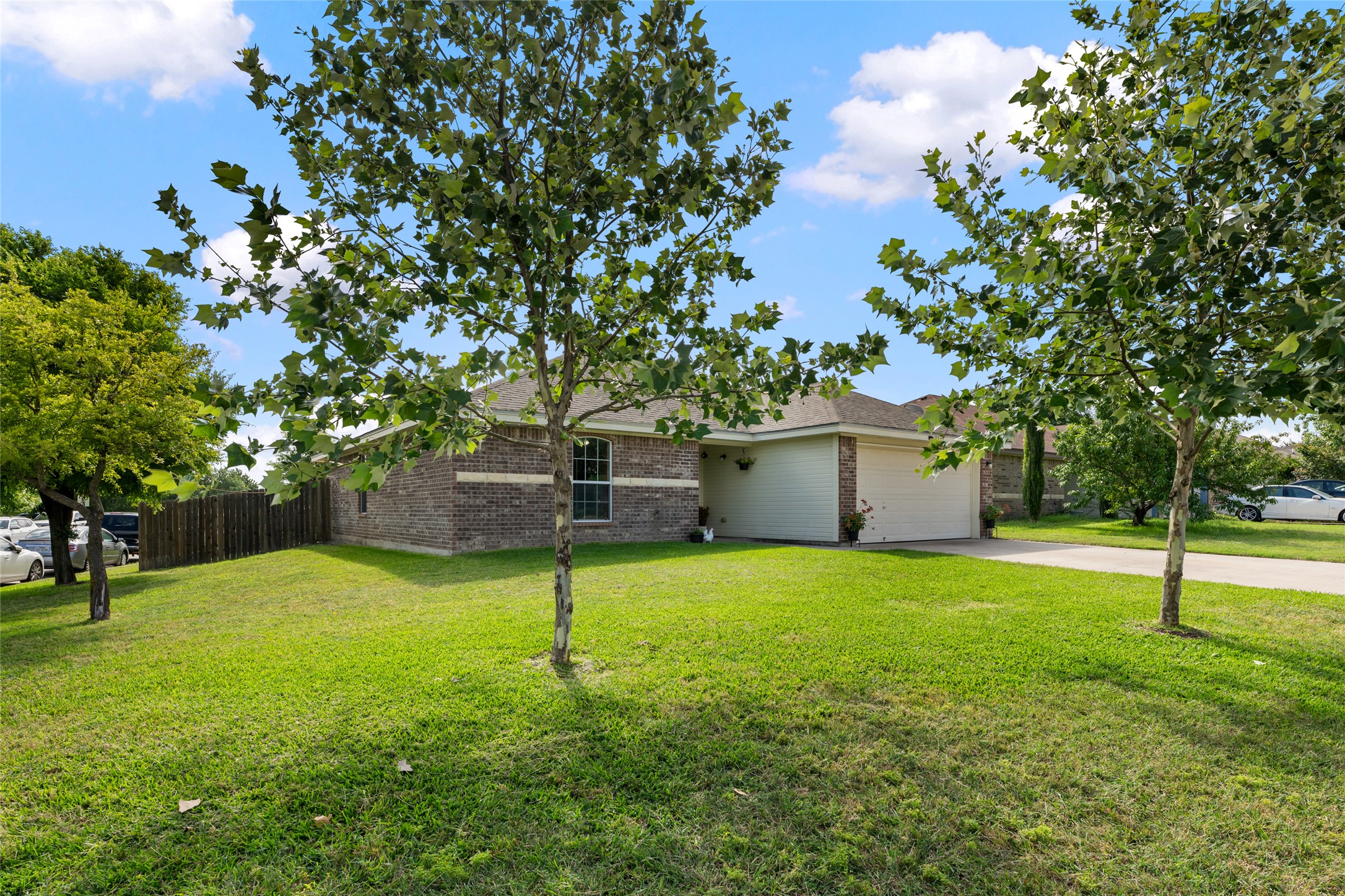 144 Calcite Lane Jarrell, TX 76537 - Photo 3 of 38 A well-maintained lawn and mature trees frame this appealing brick and siding home with an attached garage.