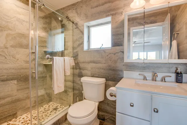 a bathroom with a sink a toilet and shower