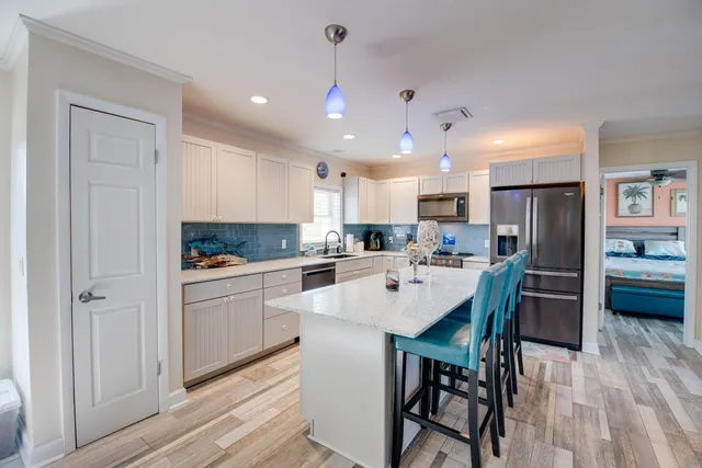 a kitchen with a dining table chairs refrigerator and cabinets