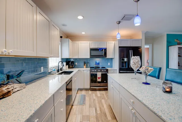 a kitchen with kitchen island granite countertop a sink appliances cabinets and a counter top space