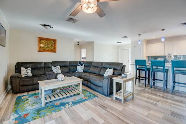 a living room with furniture and a dining table with wooden floor