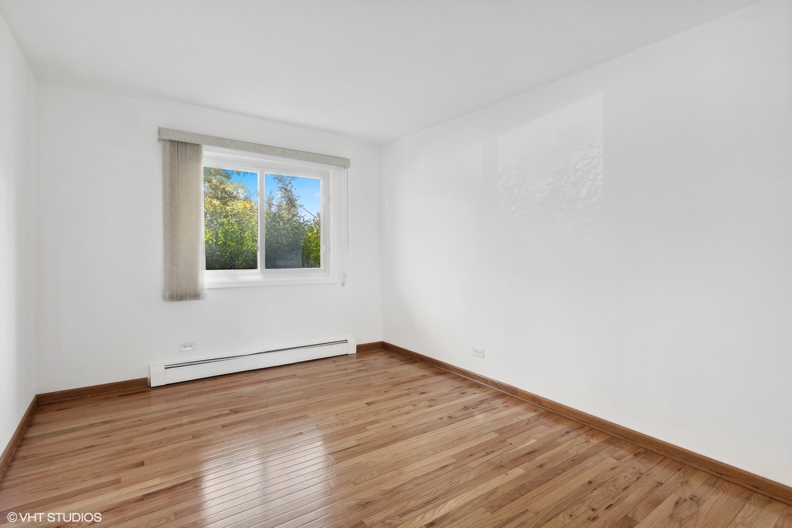 10357 Dearlove Road, Unit 1I Glenview, IL 60025 - Photo 12 of 16 a view of an empty room with wooden floor and a window