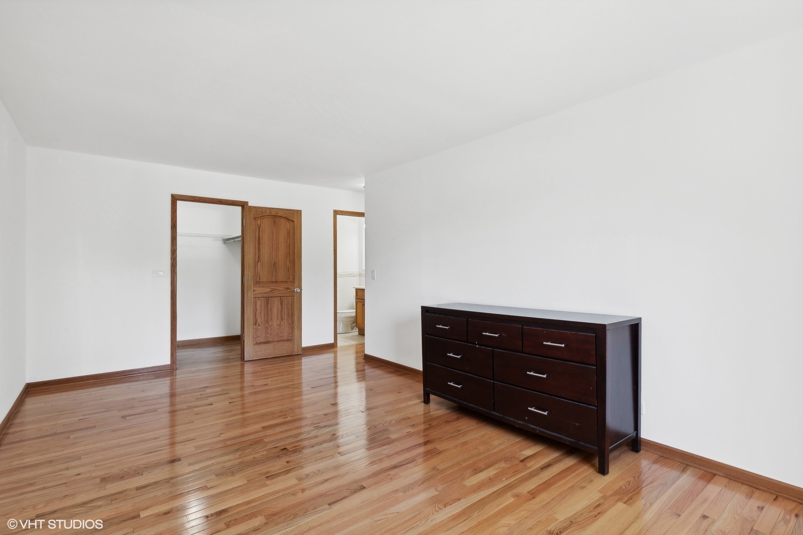 10357 Dearlove Road, Unit 1I Glenview, IL 60025 - Photo 7 of 16 a room with a dresser and a wooden floor