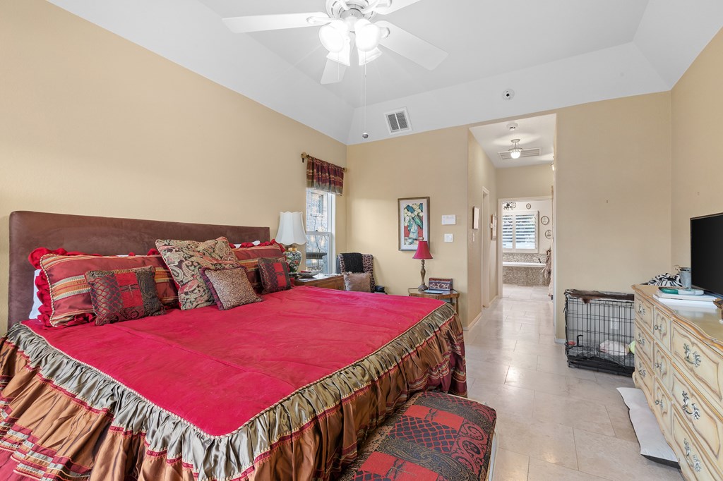 2142 Lightstone Fredericksburg, TX 78624 - Photo 12 of 30 a bedroom with a bed and a chandelier