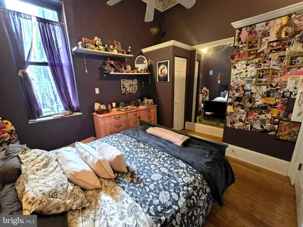 a bedroom with bed and wooden floor