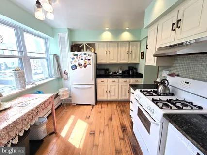 a kitchen with a stove a sink dishwasher and a refrigerator