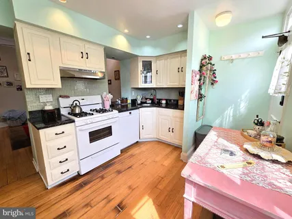 a kitchen with stainless steel appliances a stove a sink and white cabinets