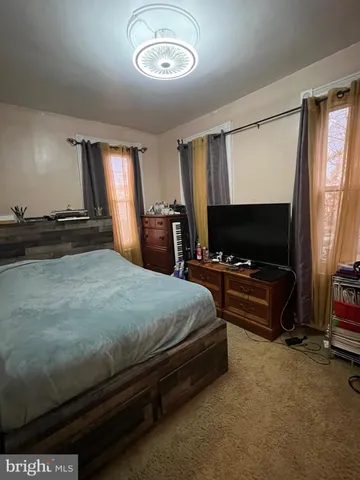 a bedroom with a bed and a flat tv screen on dresser