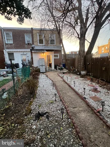 a front view of a house with a yard covered with snow and trees